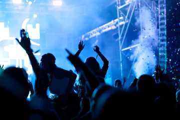 Fototapeta na wymiar cheering crowd with raised hands at concert - music festival