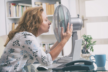 Fototapeta Woman suffers from heat in the office or at home obraz