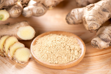 Ginger root, ginger slice and ginger powder on wooden background table, space for text.