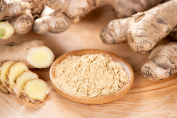 Ginger root, ginger slice and ginger powder on wooden background table, space for text.