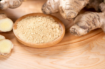 Ginger root, ginger slice and ginger powder on wooden background table, space for text.