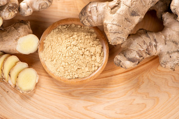 Ginger root, ginger slice and ginger powder on wooden background table, space for text.