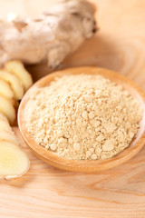 Ginger root, ginger slice and ginger powder on wooden background table, space for text.