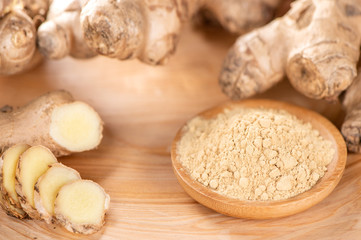 Ginger root, ginger slice and ginger powder on wooden background table, space for text.