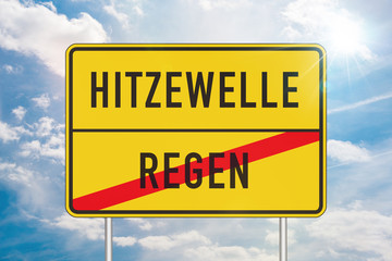 Yellow roadsign with heatwave and rain written in german against blue sky in background