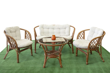 Set of garden furniture from rattan with pillows on artificial grass