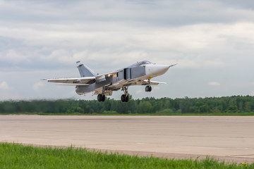 Fototapeta na wymiar Air military bomber perfoming take off from the airbase runway in Russia. Air fighter flying around base. Aviation mission of military flight.