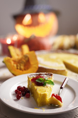 Pumpkin cake, cooked for the celebration of Halloween and decorated with cranberry and mint twig. Food photography