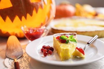 Pumpkin cake, cooked for the celebration of Halloween and decorated with cranberry and mint twig. Food photography