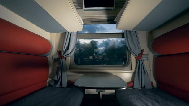 Coupe cabin of a moving train in the evening. Speed train interior.
