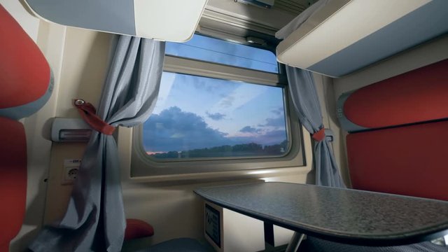 General view of a train's cabin in the twilight. Travelling by train concept. Railroad trip concept.