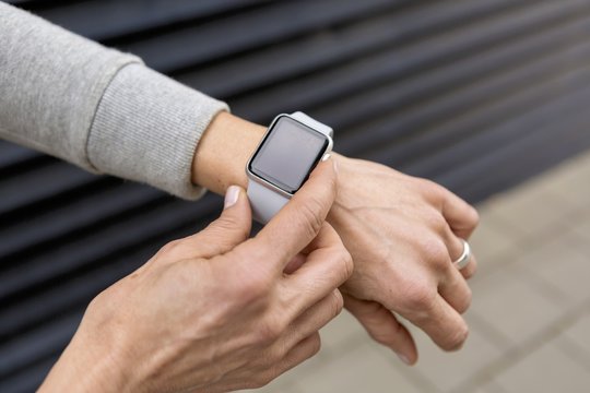 Woman's hand adjusting settings of smartwatch, close-up
