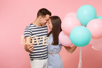Tender couple hold wooden word letters love. Woman and man in blue clothes celebrating birthday...