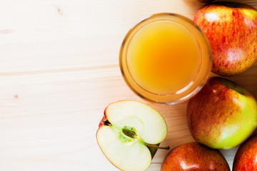 Glass of fresh apple juice and half apple near autumn apples