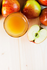 Glass of fresh apple juice and half apple near autumn apples