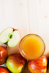 Glass of fresh apple juice and half apple near autumn apples