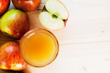 Glass of fresh apple juice and half apple near autumn apples