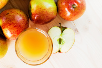 Glass of fresh apple cider near autumn apples