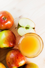 Glass of fresh apple cider near autumn apples