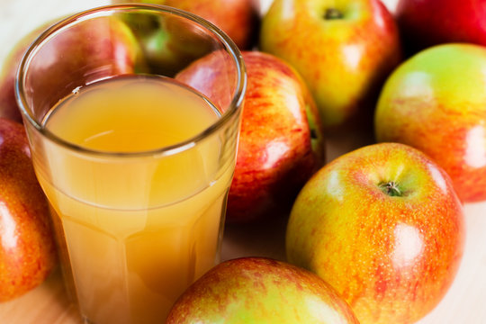 Glass of fresh apple juice near autumn apples