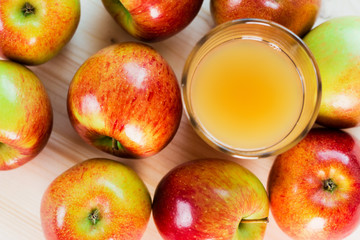 Glass of fresh apple cider near autumn apples