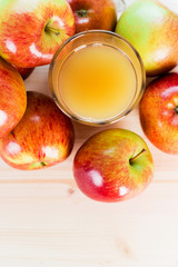 Glass of fresh apple juice near autumn apples