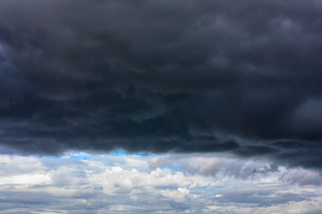 Obraz premium Stormy clouds moving in the blue sky background for rainy season and nature concept