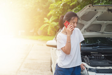 Asian woman using mobile phone and calling for help while the car broken down for transportation and vehicle concept