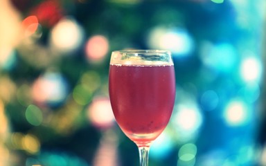 Glass of cocktails closeup blur Christmas tree lights decoration background