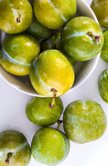 Delicious green plums fresh and raw claudias. Isolated on white background.