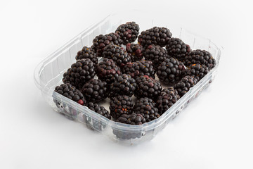 Delicious fresh blackberries and ripe black and reddish garnet. In white bowl and isolated background.