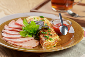 Delicious breakfast. Fried omlette with sliced ham close up