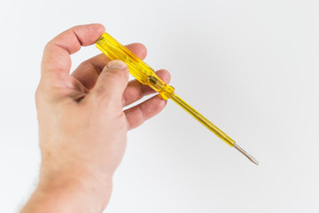 Screwdriver indicator of a phase in a male hand on a white background.