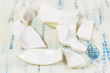 Broken and whole plate on a wooden background.