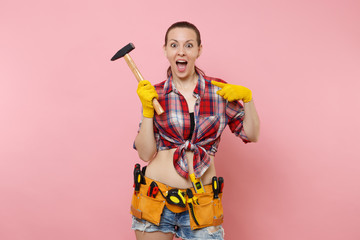 Strong young handyman woman wearing plaid shirt, denim shorts, kit tools belt full of different...