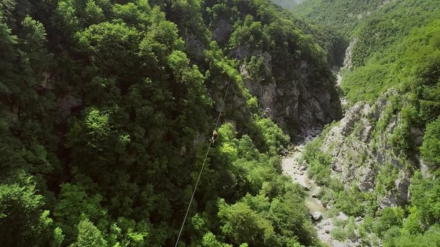 Aerial view of a person canopying over the forest in zip-line at Slovenia.