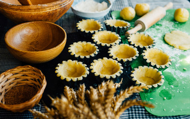 Still life in country style. Close up tartlets in baking dishes before bake.