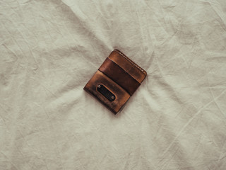 Used leather wallet left on bed.