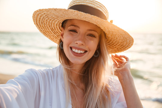 Delighted young girl in summer hat and swimwear