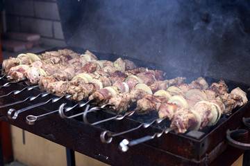 Barbecue in nature in summer. Pork meat in the smoke on the coals, healthy food, closeup.