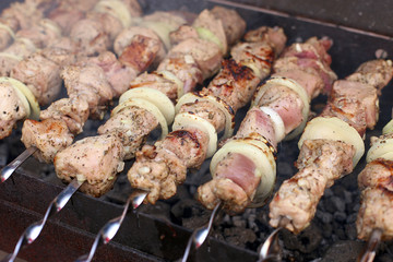Barbecue in nature in summer. Pork meat in the smoke on the coals, healthy food, closeup.