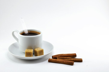 Black coffee in a white porcelain Cup with sugar and cinnamon.
