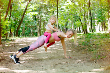 Fototapeta premium Mother and young daughter doing push ups together. Sport, Woman, Exercising, Child, Family, 
