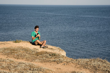 Naklejka na ściany i meble An attractive guy and a tablet. Sea and vacation. 