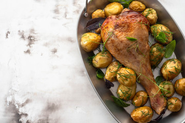 Grilled spicy turkey legs with potatoes on a white background. Copy space.