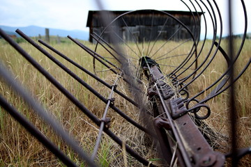 Abandoned farm equipment with historic stables