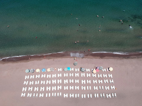 Aerial view of amazing beach with white umbrellas and turquoise sea / Black Sea Akcakoca in Turkey 