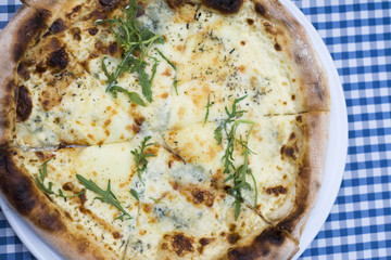 Delicious Italian cheese pizza on the table in the restaurant.