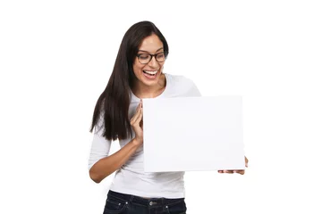 Fotobehang Junge Frau mit Brille schaut lachend auf eine leere weiße Tafel in ihren Händen © Joerch