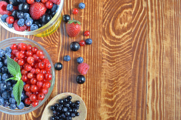 berries of red-blue color on a dark brown wooden background healthy food